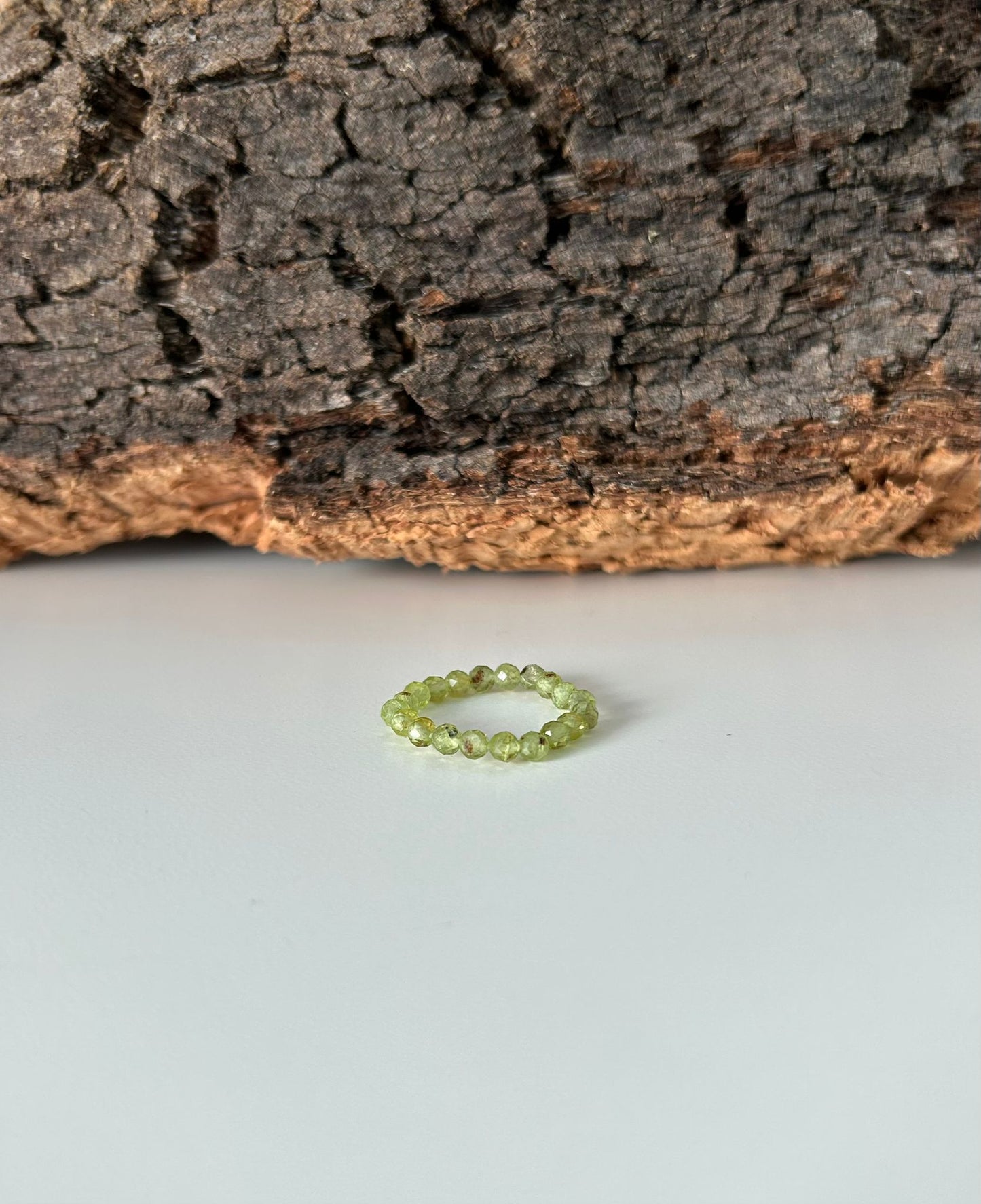 Anillo elástico de peridoto facetado