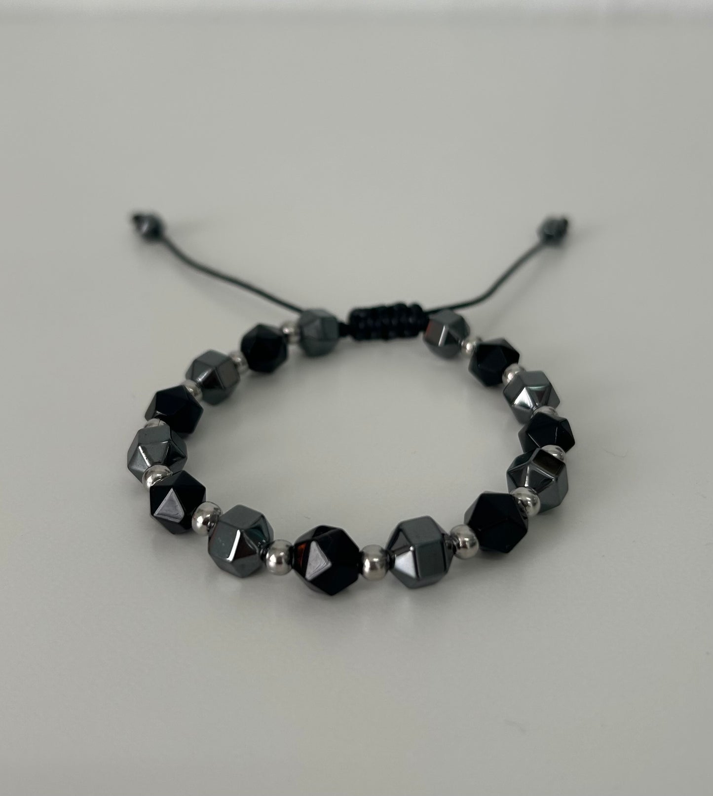 La pulsera ajustable de hematite y onix facetado.